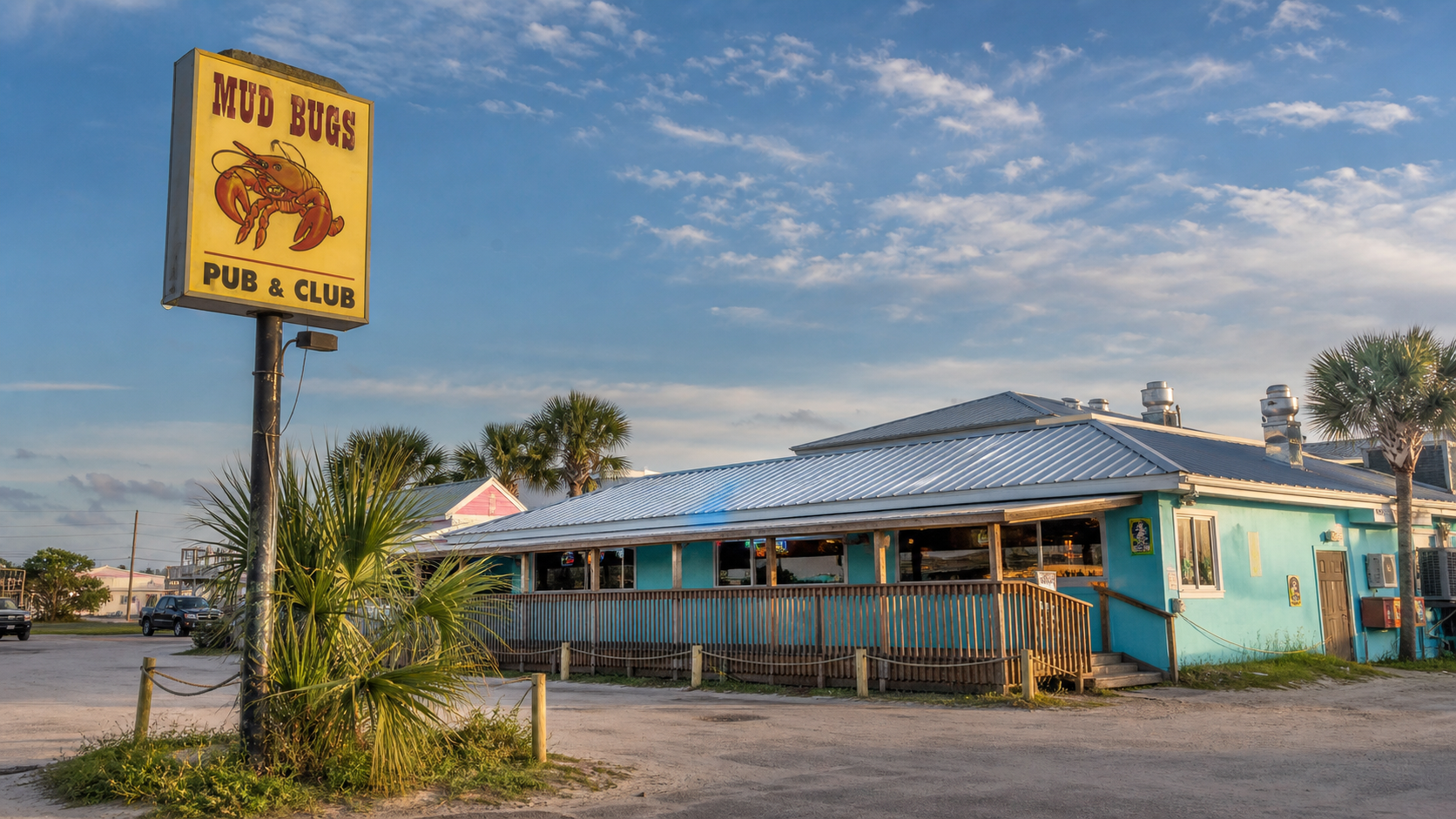 Mudbugs Dive Bar exterior in Gulf Shores with a blue roadside building and beach-town signage